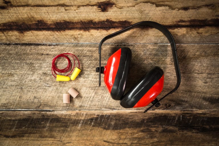 Protective Ear equipment Earplugs and Ear Protection laid out on a wooden style background