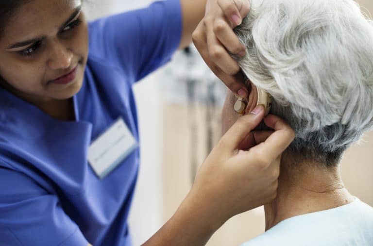 An elderly woman with hearing aid An elderly woman with hearing aid