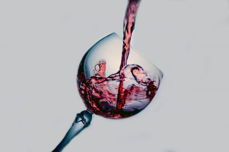 Red wine being poured into a glass.