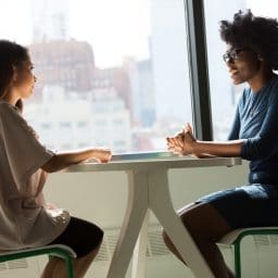 Two women having a professional conversation at a table.