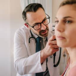 Audiologist examining a patient's ear