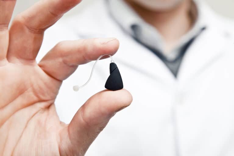 Modern hearing aids Doctor holding modern hearing aid