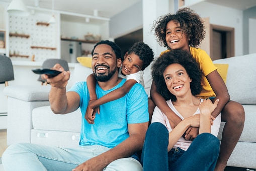 Happy family watching a movie together in a stylish living room.